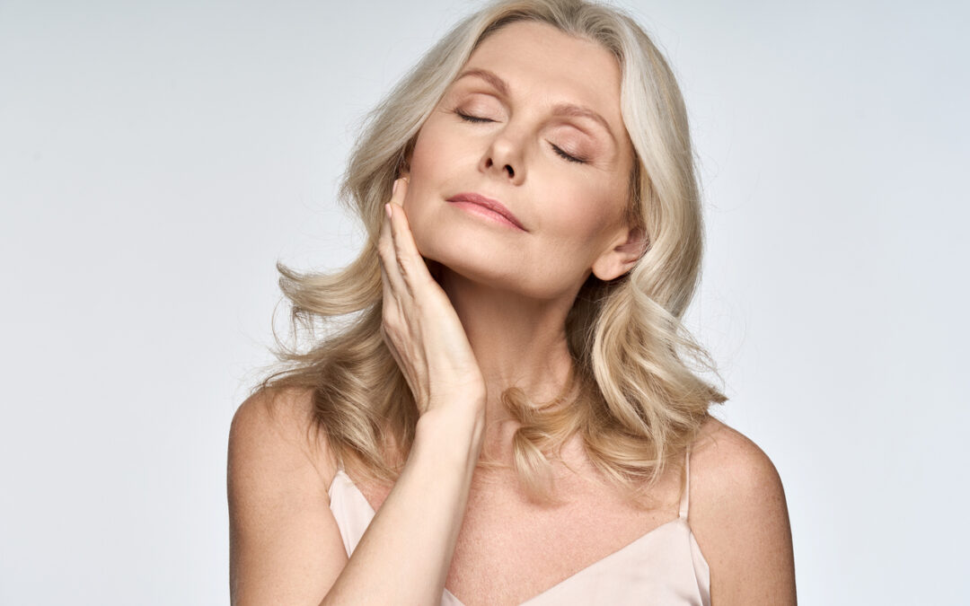 woman with closed eyes touching her perfect skin.